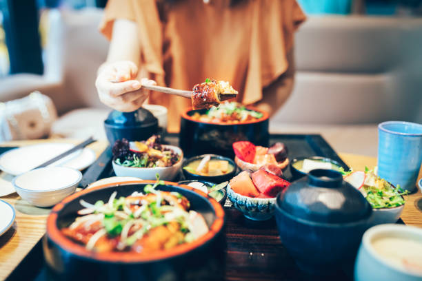 young asian woman enjoying japanese food-eel rice. - food stock pictures, royalty-free photos & images