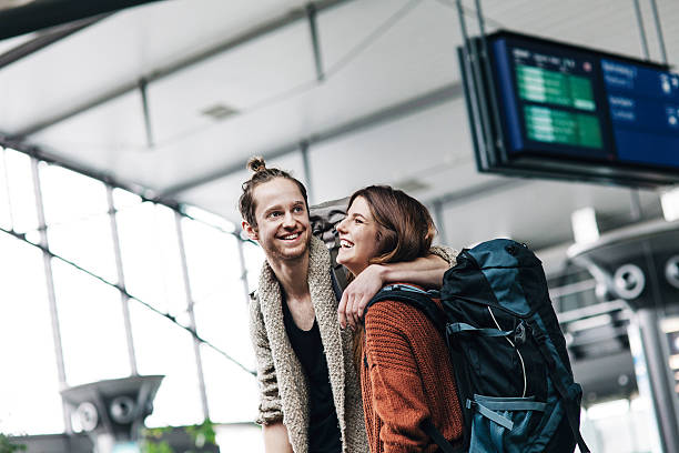 young backpacker couple at the airport - travel stock pictures, royalty-free photos & images
