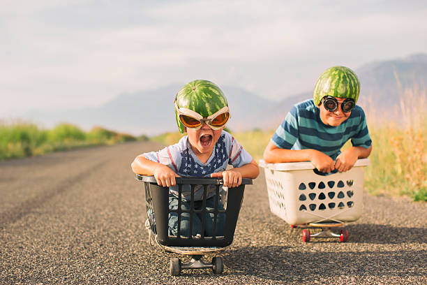 young boys racing wearing watermelon helmets - food stock pictures, royalty-free photos & images