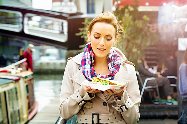 young british woman looks at take-out food with appetite - junk food stock pictures, royalty-free photos & images
