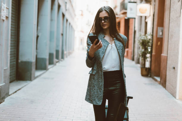 young businesswoman in the city checking cell phone - fashion stock pictures, royalty-free photos & images
