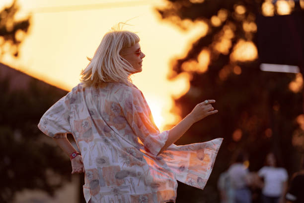 young carefree having fun while dancing on a music festival at sunset.. - concert stock pictures, royalty-free photos & images