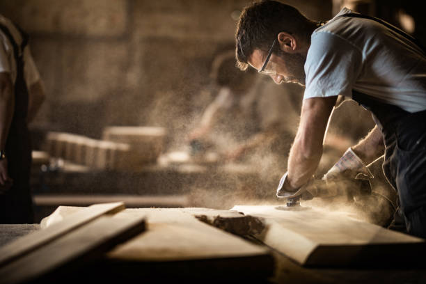 young carpenter using sander while working on a piece of wood. - home decoration stock pictures, royalty-free photos & images