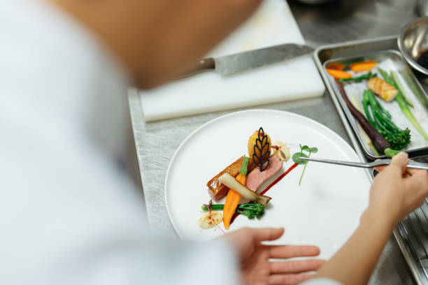 young chef preparing gourmet dish in kitchen - food stock pictures, royalty-free photos & images
