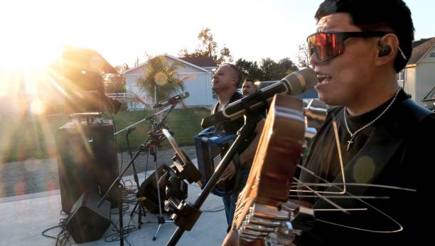 young chicano hispanic man singing performing in a latino band outdoors concert - concert stock pictures, royalty-free photos & images