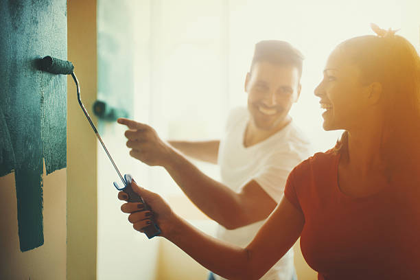 young couple decorating apartment. - home decoration stock pictures, royalty-free photos & images