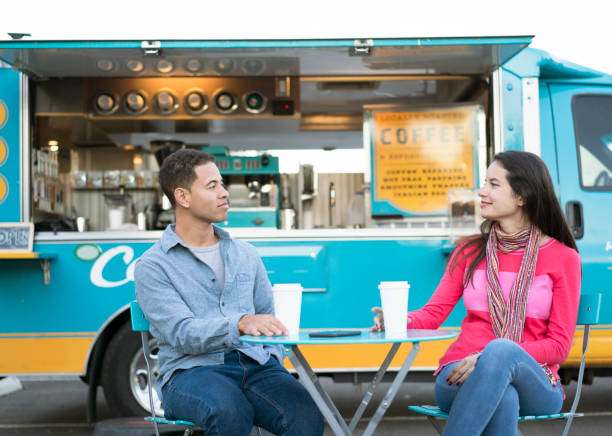 young couple drinking coffee in front of a food truck - junk food stock pictures, royalty-free photos & images
