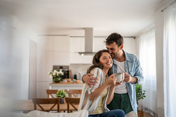 young couple drinking morning coffee enjoying the weekend in their new apartment - coffee stock pictures, royalty-free photos & images