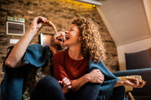 young couple eating pizza. - junk food stock pictures, royalty-free photos & images