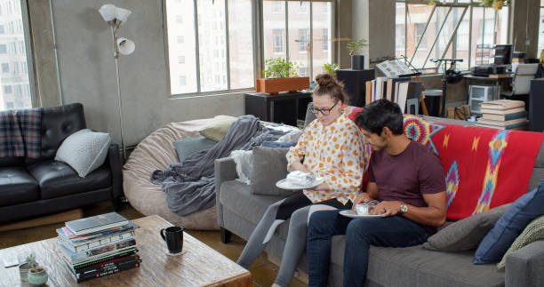 young couple eating take out food at home - junk food stock pictures, royalty-free photos & images