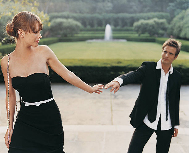young couple in evening dress parting in formal garden - garden decoration stock pictures, royalty-free photos & images