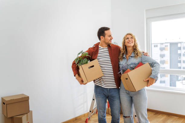 young couple in their new home - home decoration stock pictures, royalty-free photos & images