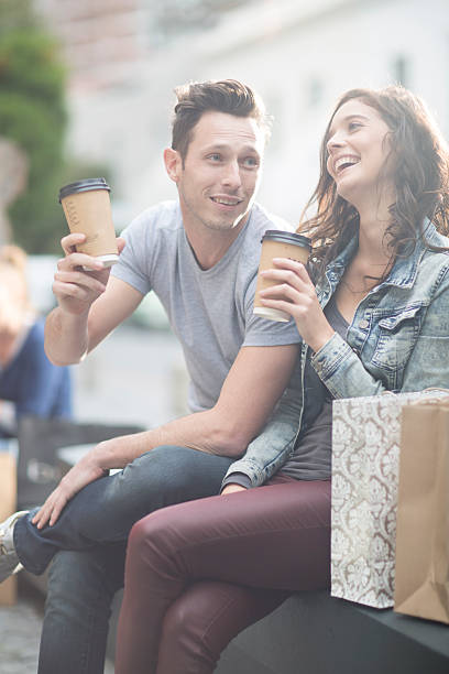 young couple relaxing with coffee to go - junk food stock pictures, royalty-free photos & images