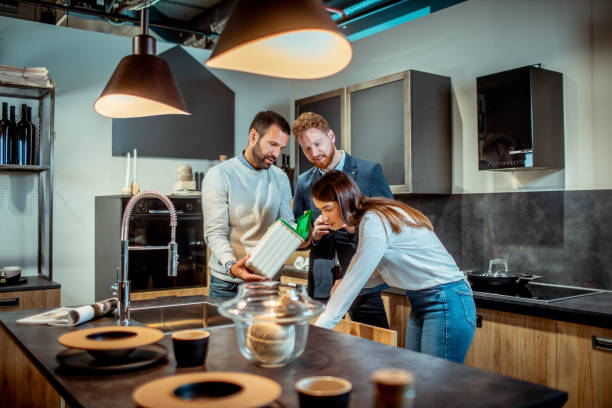 young couple shopping together in a kitchen equipment store with a salesman helping them - home decoration stock pictures, royalty-free photos & images