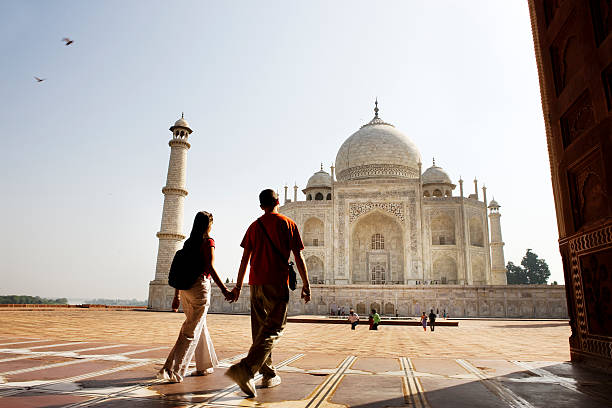 young couple walking in the taj mahal courtyard - travel stock pictures, royalty-free photos & images