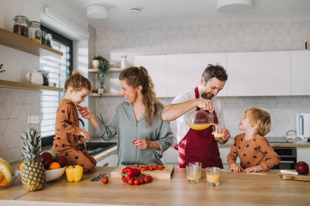 young family with two little children preparing breakfast together in kitchen. - food stock pictures, royalty-free photos & images