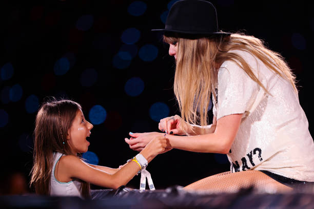 Young fan exchanges friendship bracelets with Taylor Swift as she performs onstage during "Taylor Swift | The Eras Tour" at Allianz Parque on...