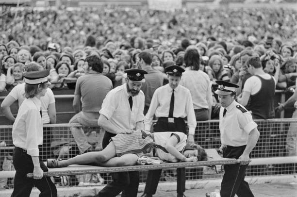 Young fan is carried out on a stretcher after being injured in a gate stampede at a concert by American singer and actor David Cassidy at White City...