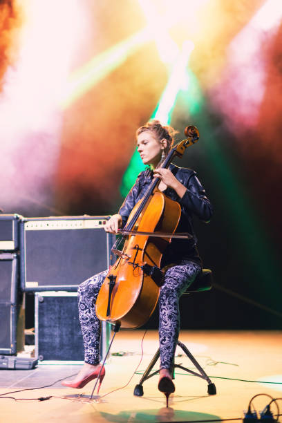young female cellist playing on a stage at the concert - concert stock pictures, royalty-free photos & images