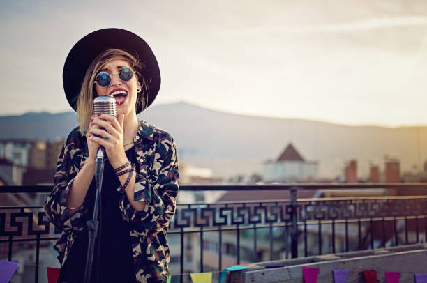 young girl is singing on the roof terrace party - concert stock pictures, royalty-free photos & images