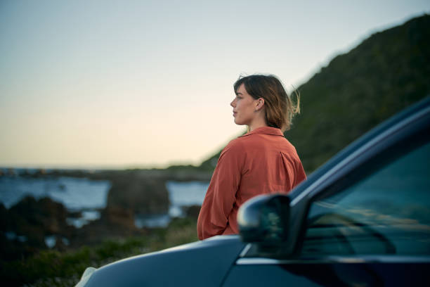young girl on the road trip look at beautiful landscape next to the car - travel stock pictures, royalty-free photos & images