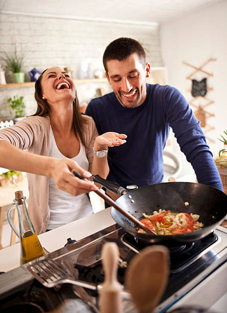 young happy attractive couple at home kitchen tasting - food stock pictures, royalty-free photos & images