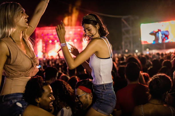 young happy couples having fun on music festival by night. - concert stock pictures, royalty-free photos & images