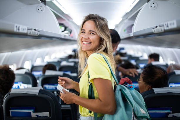 young happy woman in an airplane cabin. - travel stock pictures, royalty-free photos & images