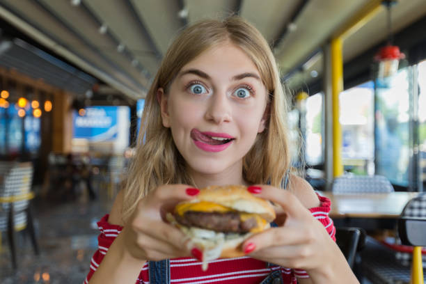 young hungry woman - junk food stock pictures, royalty-free photos & images