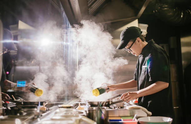 young japanese chef working in restaurant kitchen - junk food stock pictures, royalty-free photos & images