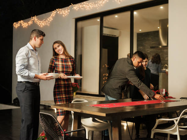 young latin people setting table for christmas meal - garden decoration stock pictures, royalty-free photos & images