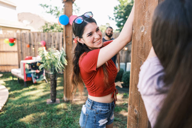 young latino people decorating at the backyard party - garden decoration stock pictures, royalty-free photos & images