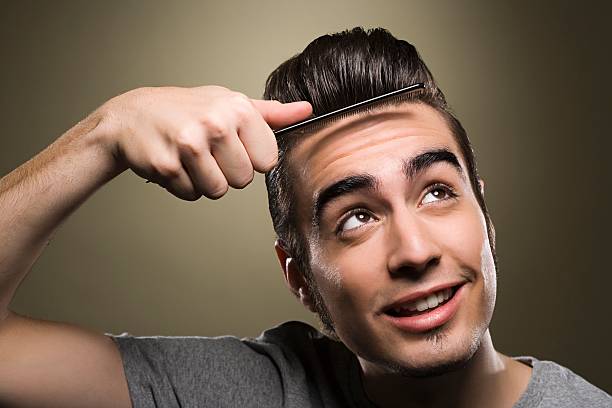 young man combing his quiff - hairstyle stock pictures, royalty-free photos & images