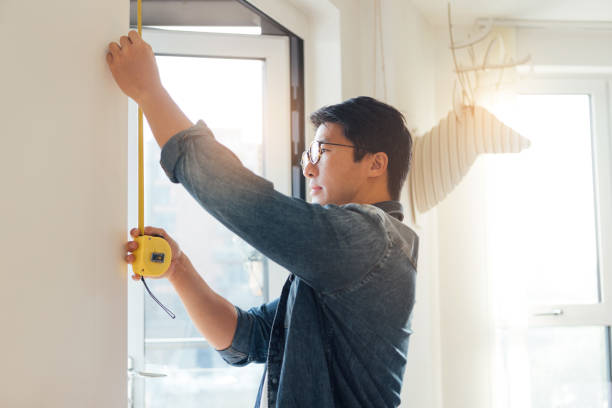 young man doing diy using measuring tape at home - home decoration stock pictures, royalty-free photos & images