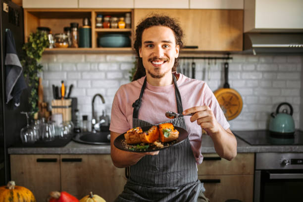 young man eating delicious and healthy dessert, pumpkin with honey and cinnamon. - food stock pictures, royalty-free photos & images