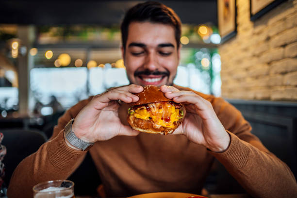 young man ready to eat a burger - food stock pictures, royalty-free photos & images