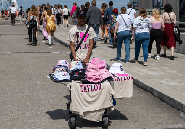 Young man sells t-shirts and hats as Fans make their way to Nissan Stadium ahead of artist Taylor Swift's second night of performance on May 6, 2023...