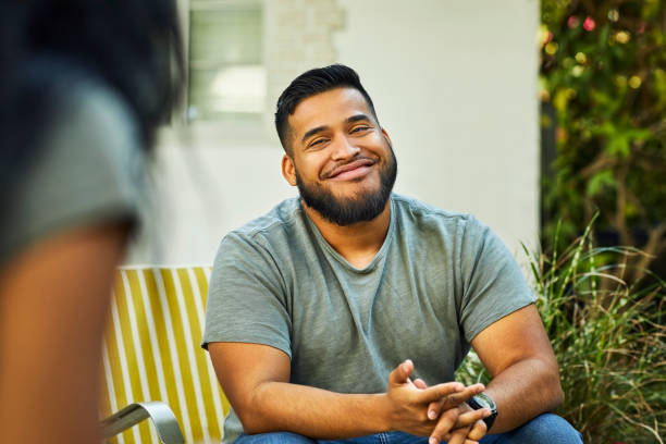 young man smiling in yard during social gathering - garden decoration photos et images de collection