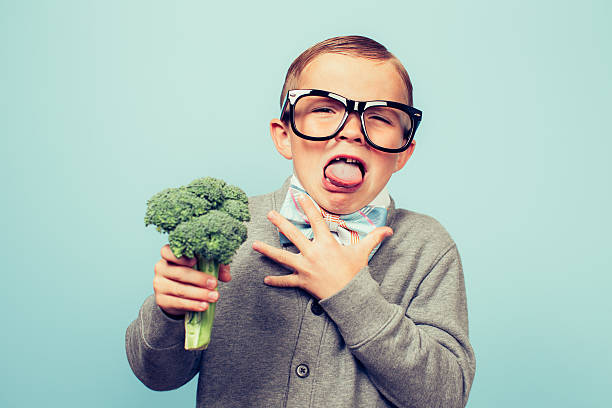 young nerd boy hates eating broccoli - food stock pictures, royalty-free photos & images