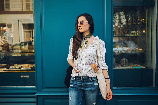 young parisian woman buying in a bakery - fashion stock pictures, royalty-free photos & images
