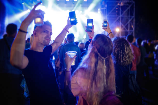 young people on music festival holding smart phones and filming - concert stock pictures, royalty-free photos & images