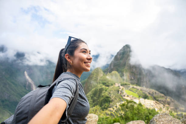 young peruvian woman taking a selfie in sacred city of machu picchu, peru - travel stock pictures, royalty-free photos & images