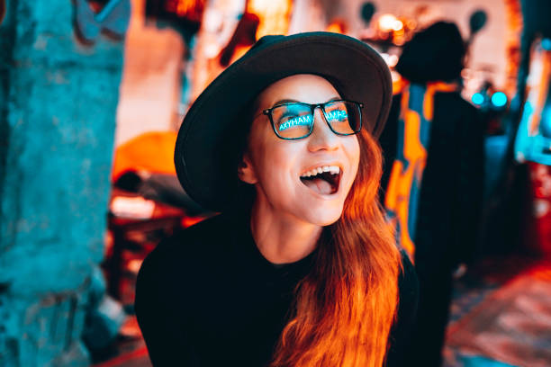 young pretty hipster woman in glasses and hat is dancing in neon lights - concert stock pictures, royalty-free photos & images