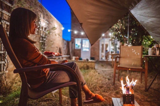 young pretty woman enjoying the campfire with friends in the garden party at home - garden decoration stock pictures, royalty-free photos & images