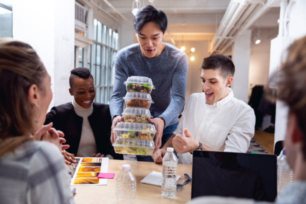 young team eating in the office at lunch break - junk food stock pictures, royalty-free photos & images