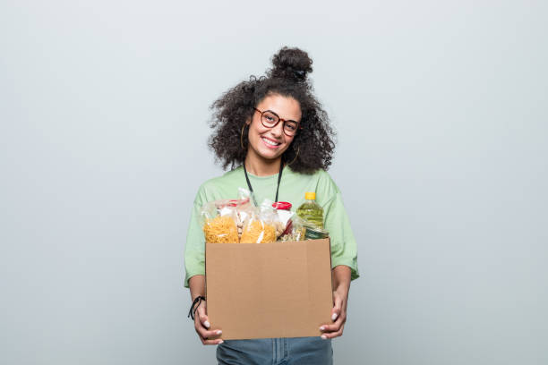 young volunteer holding donation box - food stock pictures, royalty-free photos & images