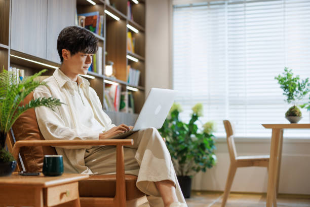young white-collar workers work with laptops in the living room - home decoration stockfoto's en -beelden
