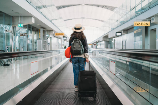 young woman at the airport with a suitcase - travel stock pictures, royalty-free photos & images