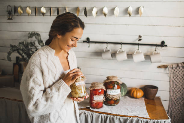 young woman cans and pickles vegetables. - food stock pictures, royalty-free photos & images