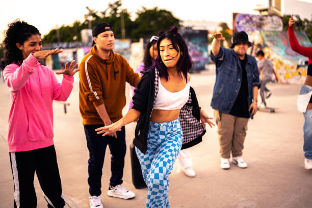 young woman dancing hip hop during street party with her friends - concert stock pictures, royalty-free photos & images